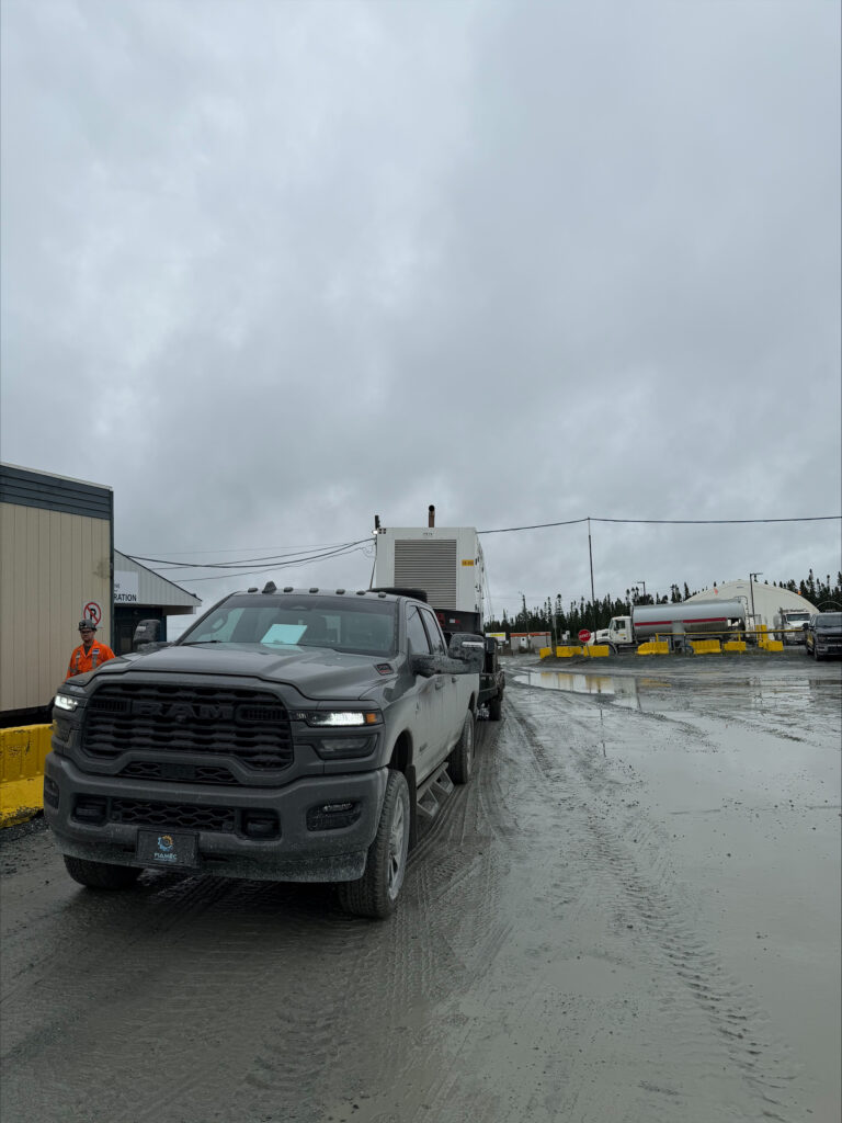 Camion FIAMEC remorquant une génératrice de chantier à l’entrée d’un site
